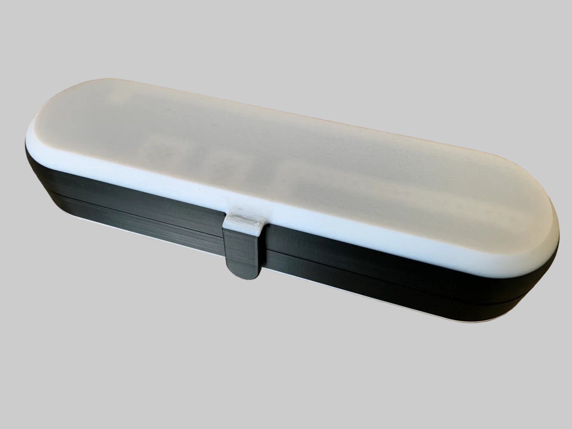 Buitenkant van een compacte 3D-geprinte Oral-B reiscase met aparte vakken voor tandenborstelonderdelen.