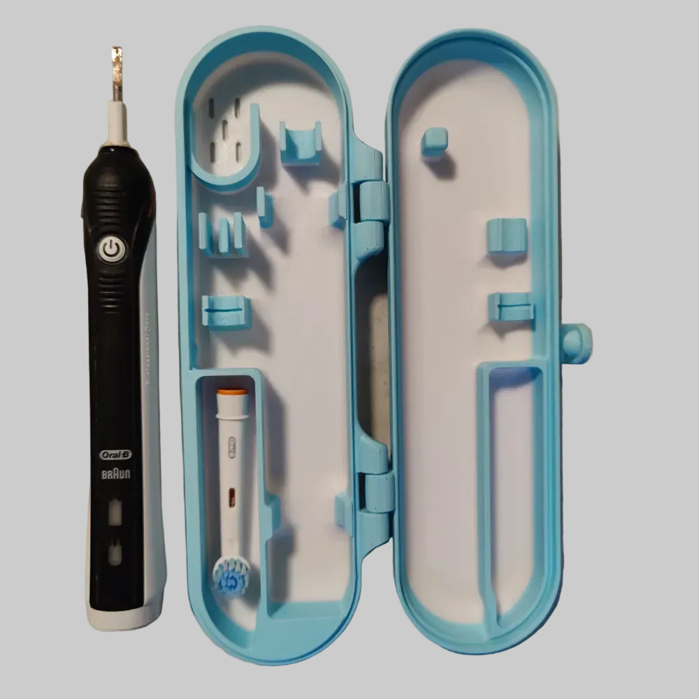 Geopende Oral-B travel case met ruimte voor een tandenborstelhandvat, twee opzetborstels en tandpasta.